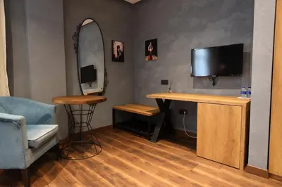 a room with a desk and a tv and a mirror at Adess Otel in Çekmeköy