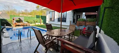 a table and chairs with an umbrella next to a pool at family villas 2 in Sapanca