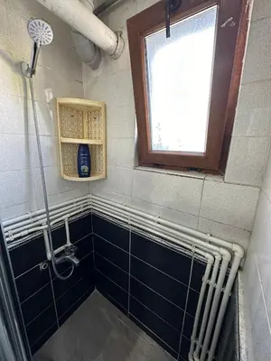 a bathroom with a shower with blue tiles and a window at Apart La Mia in Istanbul