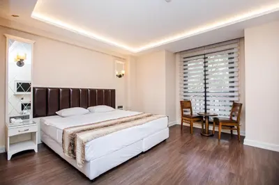 a bedroom with a large bed and a table and chairs at PRAG HOTEL in Istanbul