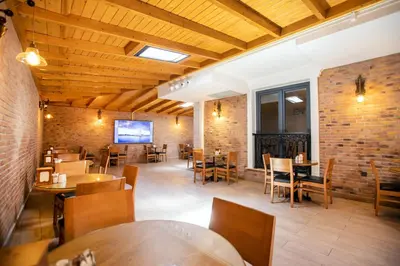 a restaurant with wooden ceilings and tables and chairs at PRAG HOTEL in Istanbul