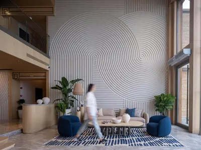 a man walking through a lobby with a couch and a person at İnemare Hotel in Demirköy