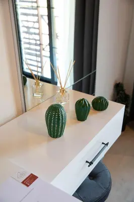 a white desk with green vases on top of it at Villa Nora Butik Otel ve Bungalov in Bursa