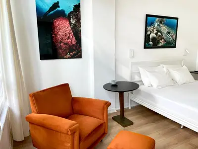 a bedroom with a bed and a chair and a table at Petek Pansiyon Fenerbahce Kadikoy in Istanbul