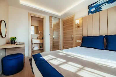 a bedroom with a large bed with blue pillows at The Milltown Hotel in Istanbul
