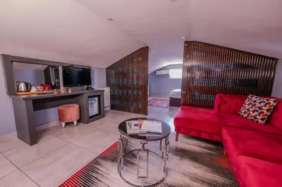 a living room with a red couch and a table at Ruby Hotel in Istanbul