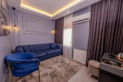 a living room with a blue couch and a chair at Ruby Hotel in Istanbul