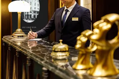 a man in a suit standing at a table with a pen at Cronton Design Hotel in Istanbul