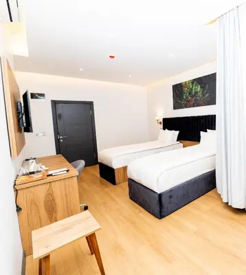 a hotel room with two beds and a table at Business Life Hotel & SPA Bakırköy in Istanbul