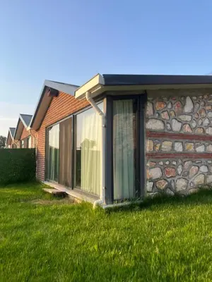 a house with a stone wall and a window at Masklavi in Kestel