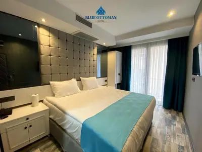 a bedroom with a large bed and a large window at Hotel Blue Ottoman in Istanbul