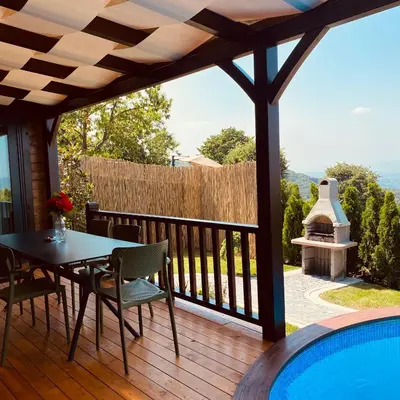 a patio with a table and chairs and a swimming pool at Kartepe Panorama in Kartepe