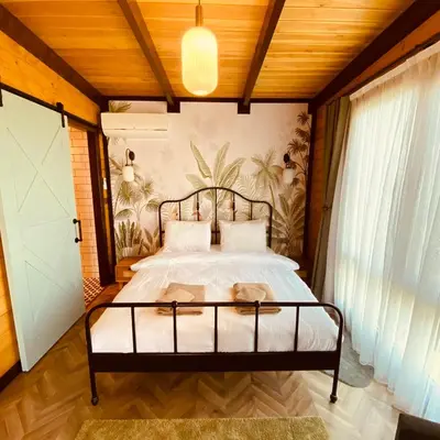 a bedroom with a bed and a wall with plants at Kartepe Panorama in Kartepe