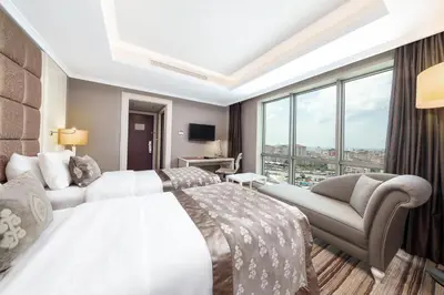 a hotel room with two beds and a couch at Dedeman Bostanci Istanbul Hotel & Convention Center in Istanbul