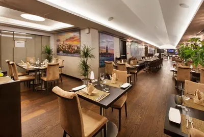 a restaurant with tables and chairs in a room at Dedeman Bostanci Istanbul Hotel & Convention Center in Istanbul