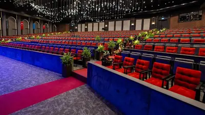 a large lecture hall with red chairs and plants at Mola İstanbul in Silivri