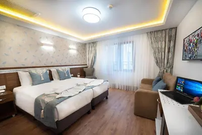 a hotel room with a large bed and a desk at Lika Hotel - Standard Double or Twin Room in Istanbul