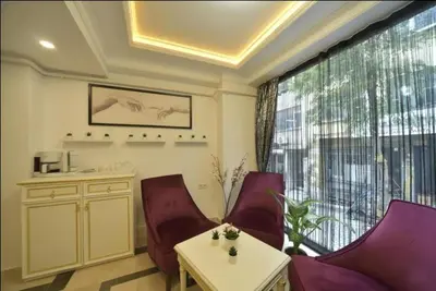 a living room with chairs and a table and a large window at Lika Hotel - Eco Double Room - Center Istanbul in Istanbul
