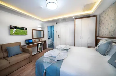 a bedroom with a large white bed and a couch at Lika Hotel - Standard Double or Twin Room in Istanbul in Istanbul