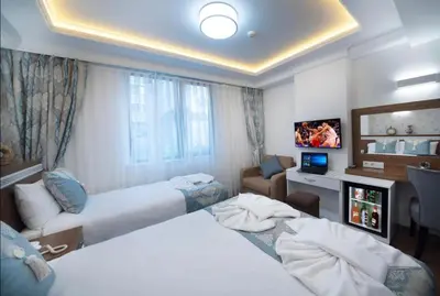 a hotel room with two beds and a television at Lika Hotel - Standard Double or Twin Room in Istanbul in Istanbul