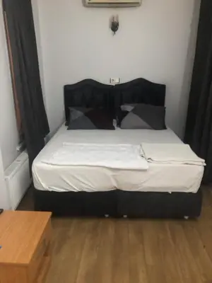 a bedroom with a bed with white sheets and pillows at Reydel Hotel in Istanbul