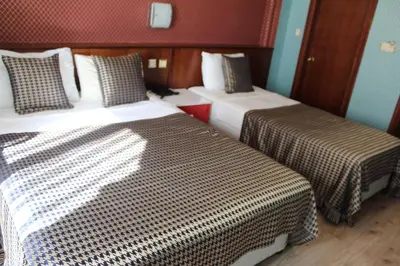 a bedroom with two beds with checkered sheets at Hotel Falcon in Istanbul