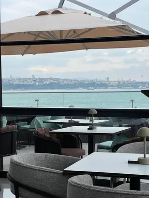 a restaurant with tables and chairs and a view of the ocean at Pera Bosphorus Hotel in Istanbul