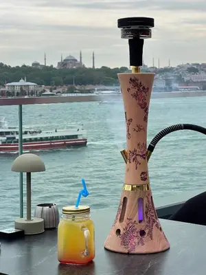 a drink dispenser sitting on a table next to the water at Pera Bosphorus Hotel in Istanbul