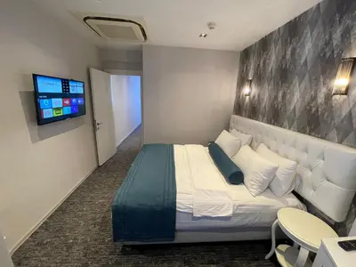 a hotel room with a bed and a flat screen tv at Weingart Seaside Hotel in Istanbul