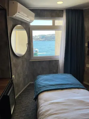 a bedroom with a bed and a window in a boat at Weingart Seaside Hotel in Istanbul