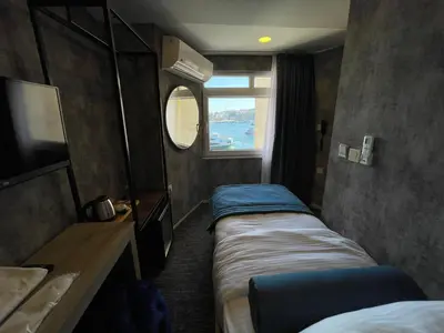 a small room with three beds and a window at Weingart Seaside Hotel in Istanbul