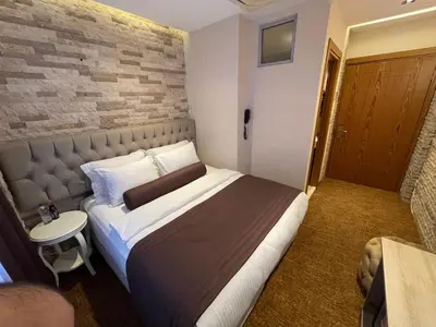 a bedroom with a large bed with a brick wall at Weingart Seaside Hotel in Istanbul