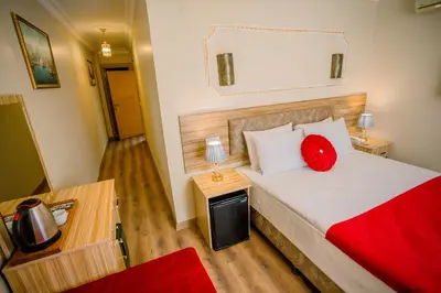 a bedroom with a bed with a red pillow on it at Gülec Konak Hotel in Istanbul