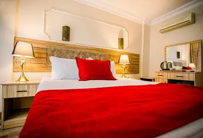 a bedroom with a red bed with a red blanket at Gülec Konak Hotel in Istanbul
