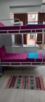 a room with two bunk beds and a rug at XALİLA HOSTEL & CAFE, MEN's ROOM, BEST IN ISTANBUL , in Istanbul