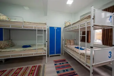 a room with two bunk beds and a rug at XALİLA HOSTEL & CAFE, MEN's ROOM, BEST IN ISTANBUL , in Istanbul