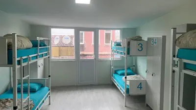 a room with three bunk beds with blue pillows at XALİLA HOSTEL & CAFE, MEN's ROOM, BEST IN ISTANBUL , in Istanbul