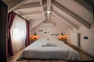 a bedroom with a large white bed in a attic at Tree Bungalov Maşukiye in Kartepe