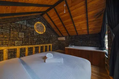 a bedroom with a bed and a bath tub at Tree Bungalov Maşukiye in Kartepe