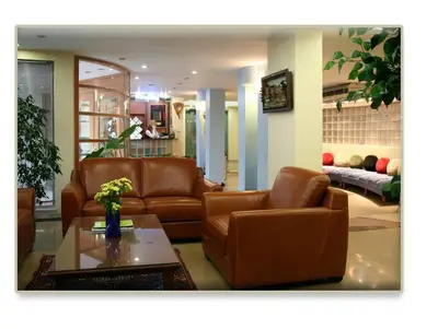 a living room with brown leather furniture and a table at ViP Apartments in Çekirge