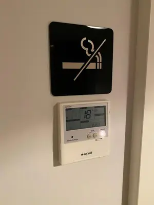a clock on a wall with a no smoking sign at The Y Istanbul Suites in Istanbul