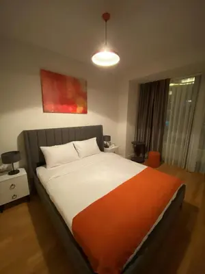 a bedroom with a bed with an orange and white blanket at The Y Istanbul Suites in Istanbul
