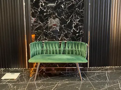 a green chair sitting in front of a wall at iNALENS AİRPORT HOTEL in Arnavutköy