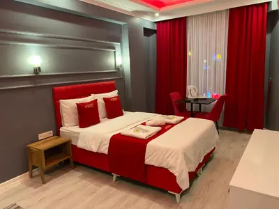 a bedroom with a large bed with red accents at iNALENS AİRPORT HOTEL in Arnavutköy