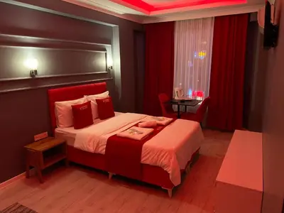 a bedroom with a large bed with a red headboard at iNALENS AİRPORT HOTEL in Arnavutköy