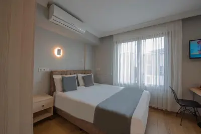 a bedroom with a large white bed and a window at Seven Studıos Sultanahmet in Istanbul