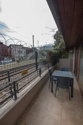 a table and chairs on a balcony with a view of train tracks at Seven Studıos Sultanahmet in Istanbul