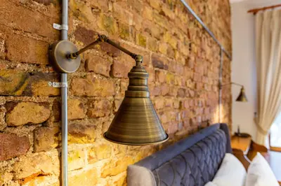a bell hanging on a brick wall next to a bed at Ganbaru Tours - Private Triplex&Duplex in Istanbul