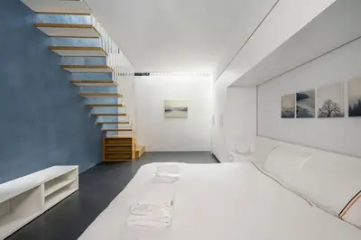 a bedroom with a white bed and a staircase at Newly Designed Central Modern Smart Duplex! #143 in Istanbul