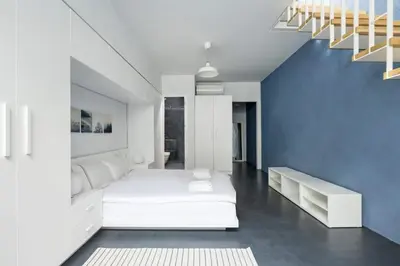 a bedroom with a white bed and a blue wall at Newly Designed Central Modern Smart Duplex! #143 in Istanbul